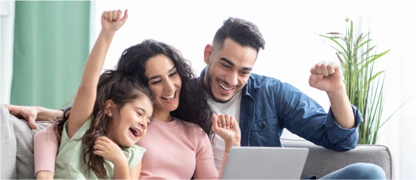 A happy family in front of a laptop.