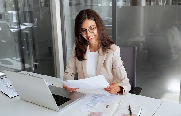 a smiling woman works in light office